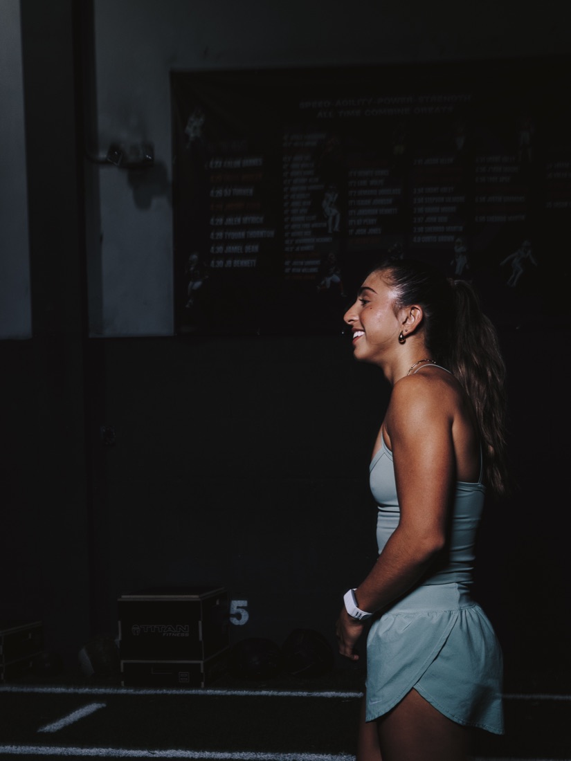 An athlete smiling between sets in the gym.